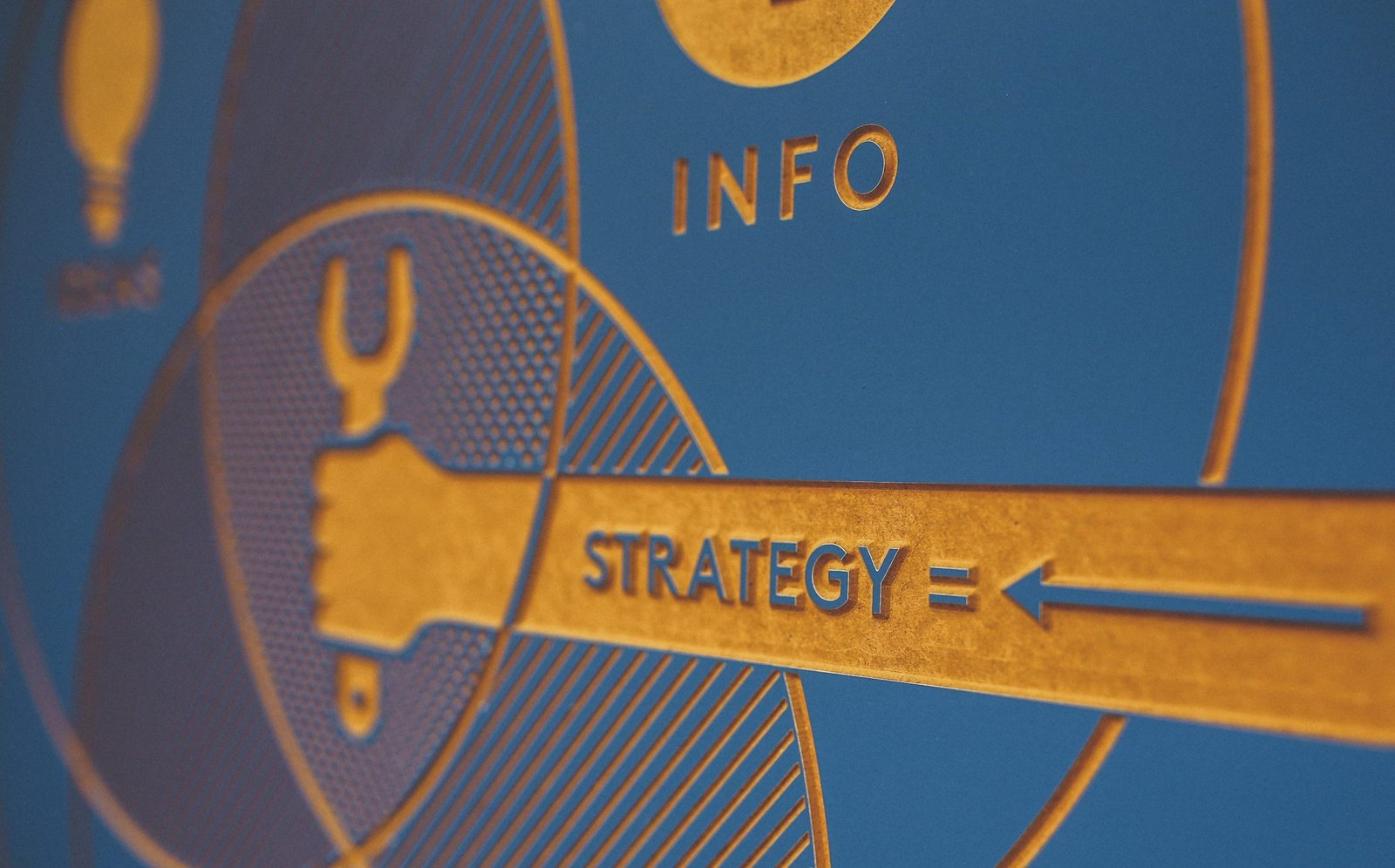 illustration of a hand holding a tool. Words "Strategy" and "Info" are printed.
